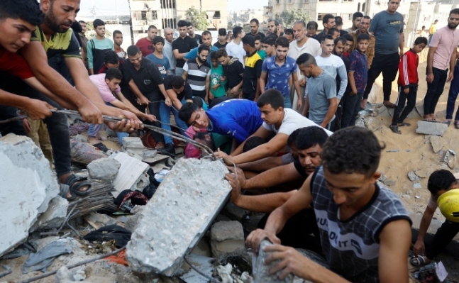 맨손으로 구하고 팔레스타인 가자지구의 칸유니스 주민들이 16일(현지시간) 이스라엘군의 공격으로 파괴된 건물 잔해에서 사상자를 수색하고 있다. 로이터 연합뉴스
