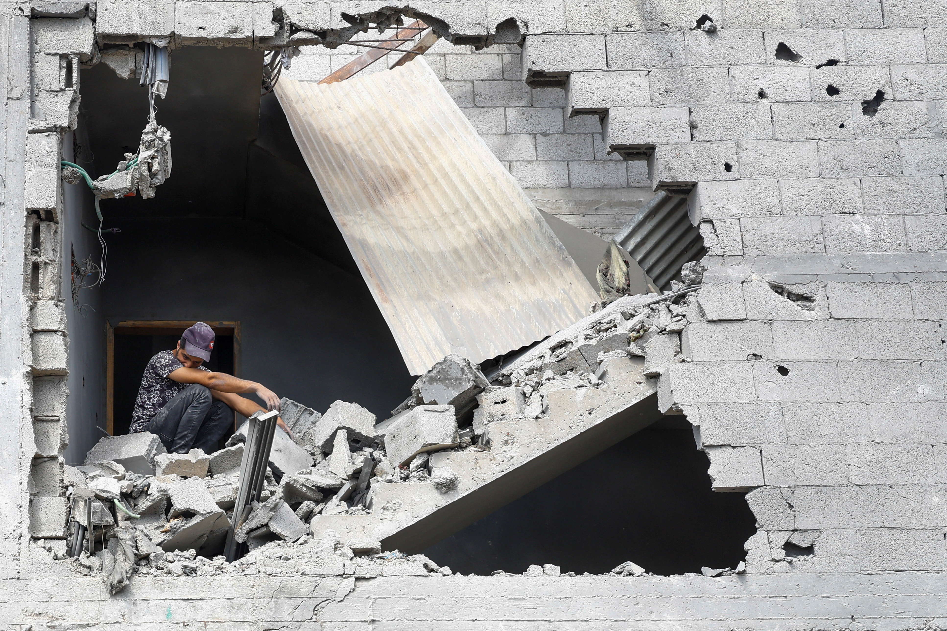 16일 가자지구 남부 칸 유니스에서 이스라엘의 공습으로 파괴된 집터에 한 남자가 앉아 있다. 로이터 연합뉴스