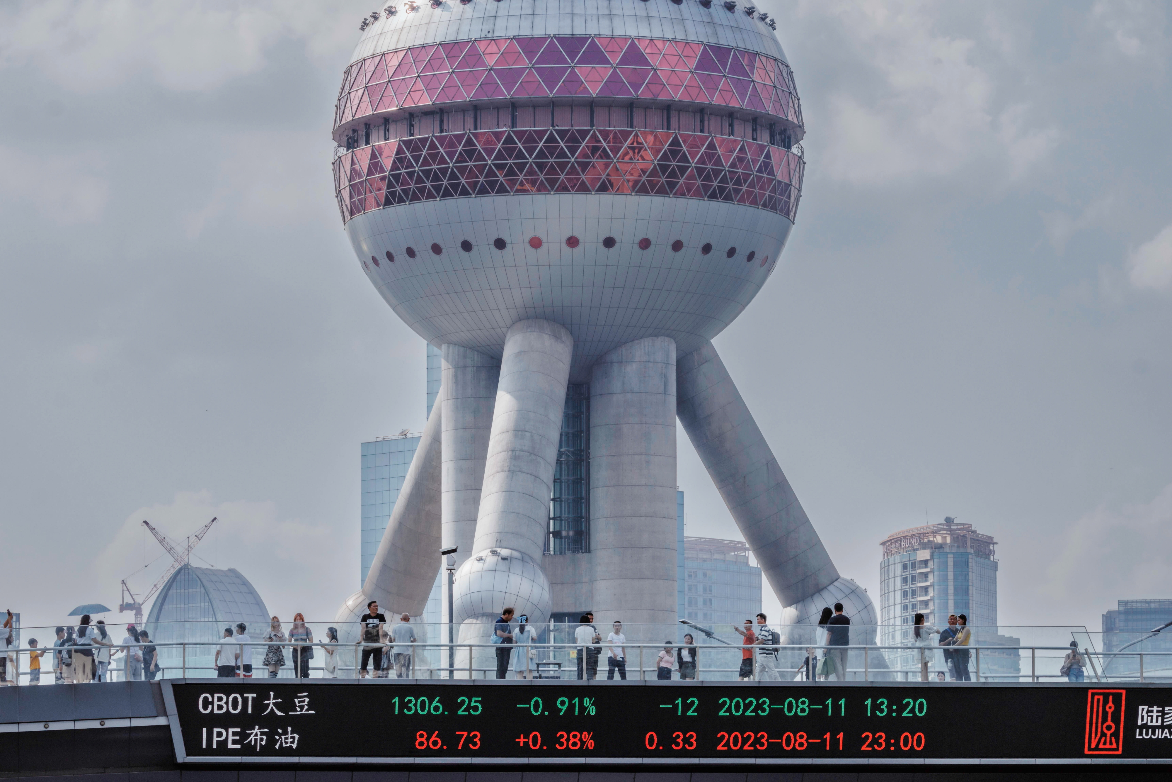 21일 중국 상하이에서 증권거래소 주식 시세를 보여주는 화면이 있는 보행자 다리 위를 사람들이 걸어가고 있다. 2023.8.21 EPA 연합뉴스