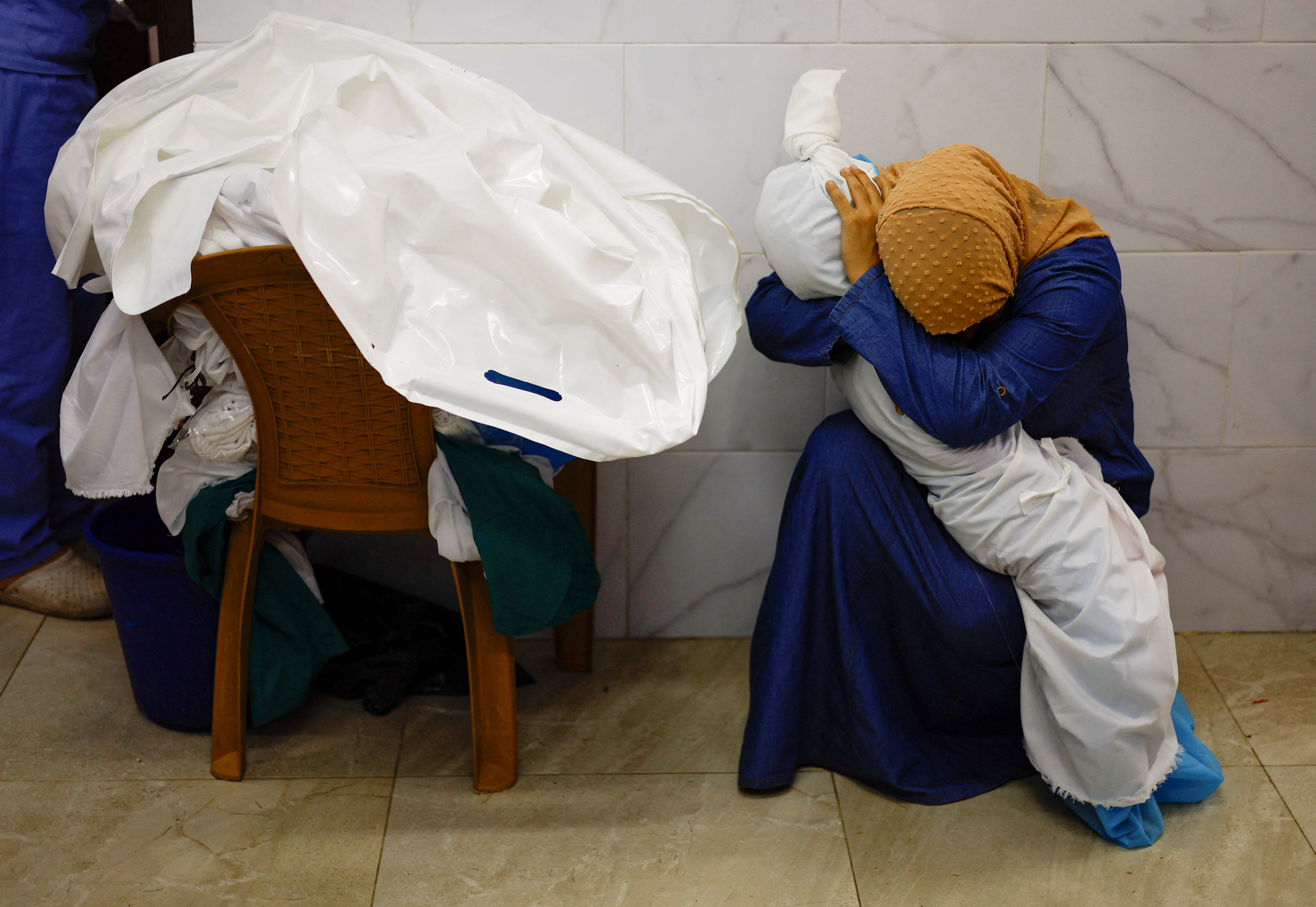 17일 가자지구 남부 칸 유니스의 한 병원에서 한 여성이 이스라엘의 공습으로 사망한 팔레스타인 아이의 시신을 껴안고 눈물을 흘리고 있다. 로이터/모하메드 살렘