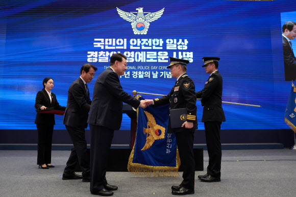 윤석열 대통령이 18일 청와대 영빈관에서 열린 제78주년 경찰의날 기념식에서 부산경찰청에 단체포상(대통령 표창)한 후 우철문 부산경찰장을 격려하고 있다. 2023.10.18. 대통령실 제공