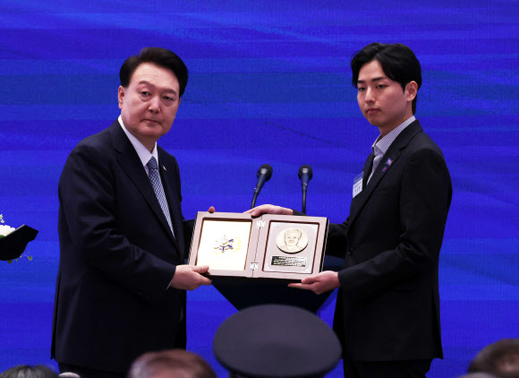 윤석열 대통령이 18일 청와대 영빈관에서 열린 제78주년 경찰의날 기념식에서 순직한 고 이종우 경감의 유가족에게 ‘경찰 영웅패’를 수여하고 있다. 2023.10.18 연합뉴스
