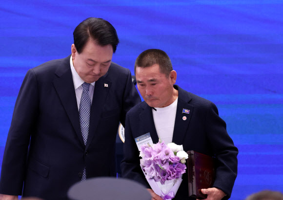 윤석열 대통령이 18일 청와대 영빈관에서 열린 제78주년 경찰의날 기념식에서 순직한 고 강삼수 경위의 유가족에게 ‘경찰 영웅패’를 수여한 뒤 위로하고 있다.  2023.10.18 연합뉴스