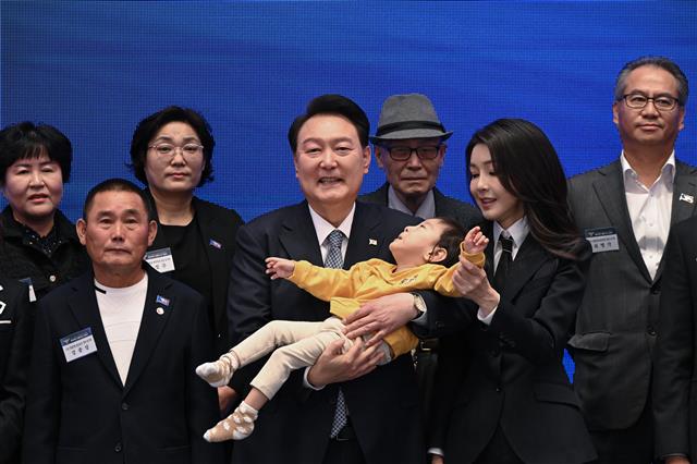 윤석열 대통령과 김건희 여사가 18일 청와대 영빈관에서 열린 제78주년 경찰의날 기념식에서 2020년도 경찰영웅 유재국 경위의 자녀를 안아주며 순직 경찰 유가족들과 기념 촬영을 하고 있다. 2023.10.18. 대통령실 제공