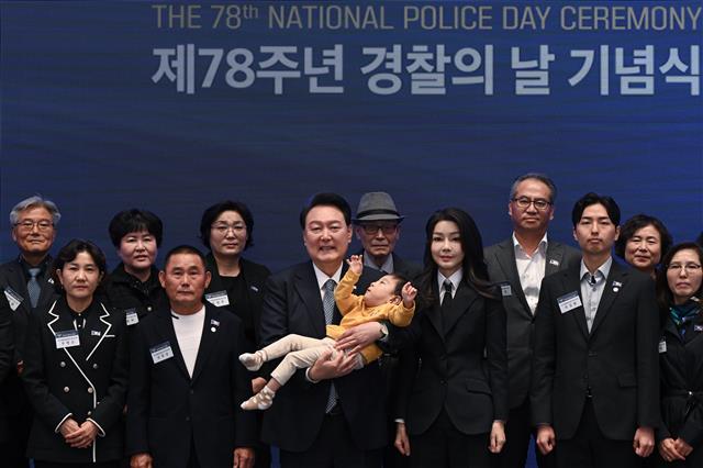 윤석열 대통령과 김건희 여사가 18일 청와대 영빈관에서 열린 제78주년 경찰의날 기념식에서 2020년도 경찰영웅  유재국 경위의 자녀를 안아주며 순직 경찰 유가족들과 기념 촬영을 하고 있다. 2023.10.18. 대통령실 제공