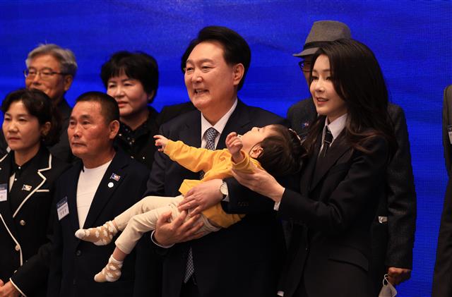 윤석열 대통령과 김건희 여사가 18일 청와대 영빈관에서 열린 제78주년 경찰의날 기념식에서 2020년도 경찰영웅 고 유재국 경위의 자녀를 안아주며 순직 경찰 유가족들과 기념 촬영을 하고 있다. 2023.10.18. 대통령실 제공