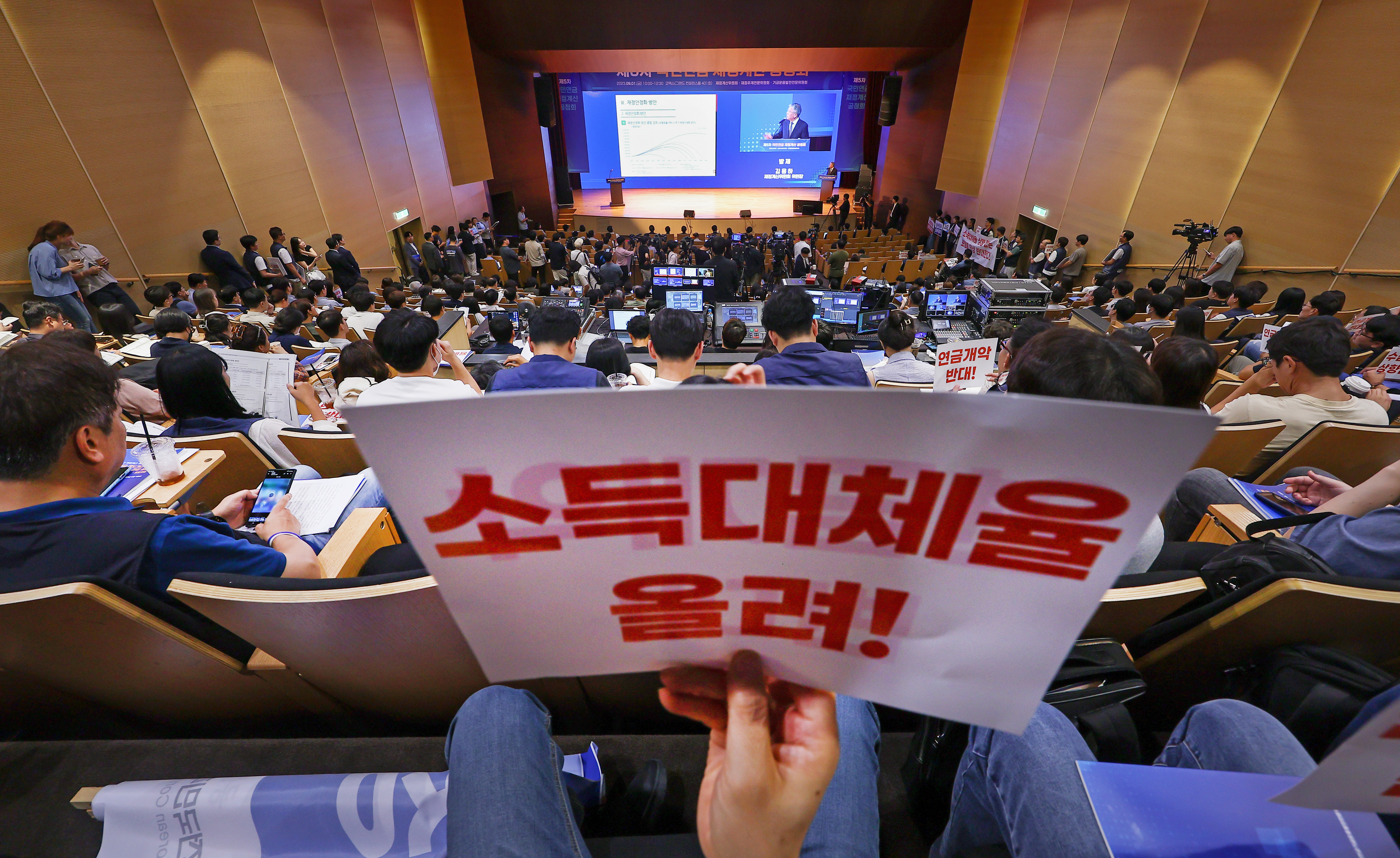 공적연금강화국민운동(연금행동) 활동가들이 지난달 1일 서울 강남구 코엑스에서 열린 국민연금 재정계산위원회 공청회에서 소득대체율을 올리라는 내용의 피켓을 들고 있다.  연합뉴스