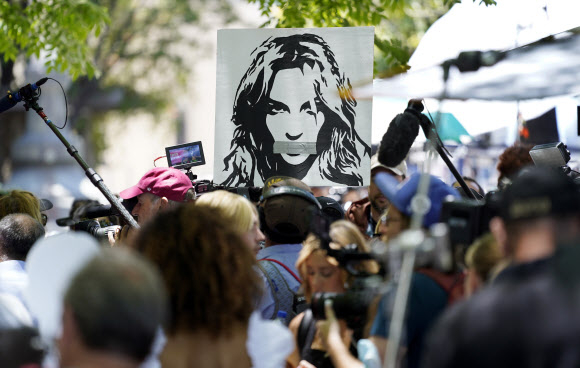 팝가수 브리트니 스피어스의 지지자들이 지난 2021년 6월 23일(현지시간) 미국 캘리포니아주 로스앤젤레스(LA) 카운티 스탠리 모스크 법원 앞에서  ‘브리트니를 해방하라(Free Britney)’라고 적힌 피켓 등을 들고 시위를 벌이는 가운데 취재진들이 취재로 분주하다. AP 연합뉴스