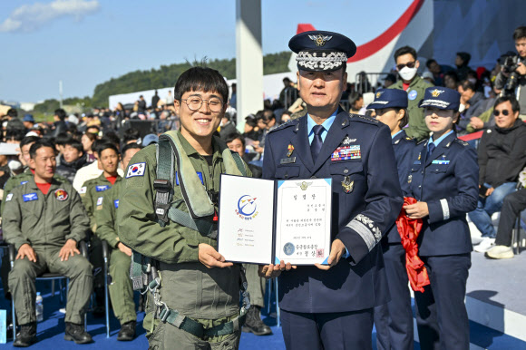 21일 경기도 성남 서울공항 ADEX 행사장에서 열린 제9기 국민조종사 및 명예조종사 임명식에서 세계 최연소로 4대 극지마라톤을 완주한 유동현 국민조종사가 정상화 공군 참모총장과 함께 임명장을 들고 기념촬영을 하고 있다. 2023.10.21. 공군 제공