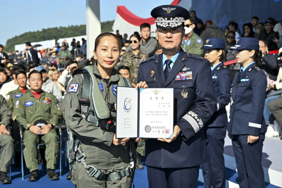 21일 경기도 성남 서울공항 ADEX 행사장에서 열린 제9기 국민조종사 및 명예조종사 임명식에서 베트남에서 온 이민자 이호정 국민조종사가 정상화 공군 참모총장과 함께 임명장을 들고 기념촬영을 하고 있다. 2023.10.21. 공군 제공