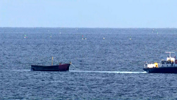 북한 주민 4명이 24일 소형 목선을 타고 동해 북방한계선(NLL) 아래로 내려와 속초 앞바다에서 우리 어민에 의해 발견된 가운데 이날 오후 군 당국이 소형 목선을 양양군 기사문항으로 예인하고 있다. 2023.10.24  연합뉴스TV 제공