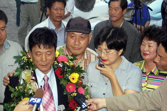 김병도(왼쪽)씨가 납북됐을 당시 신생아였던 딸 영아씨와 2003년 7월 23일 경남 통영에서 감격의 상봉을 한 뒤 기자들의 질문에 답하고 있다. 연합뉴스