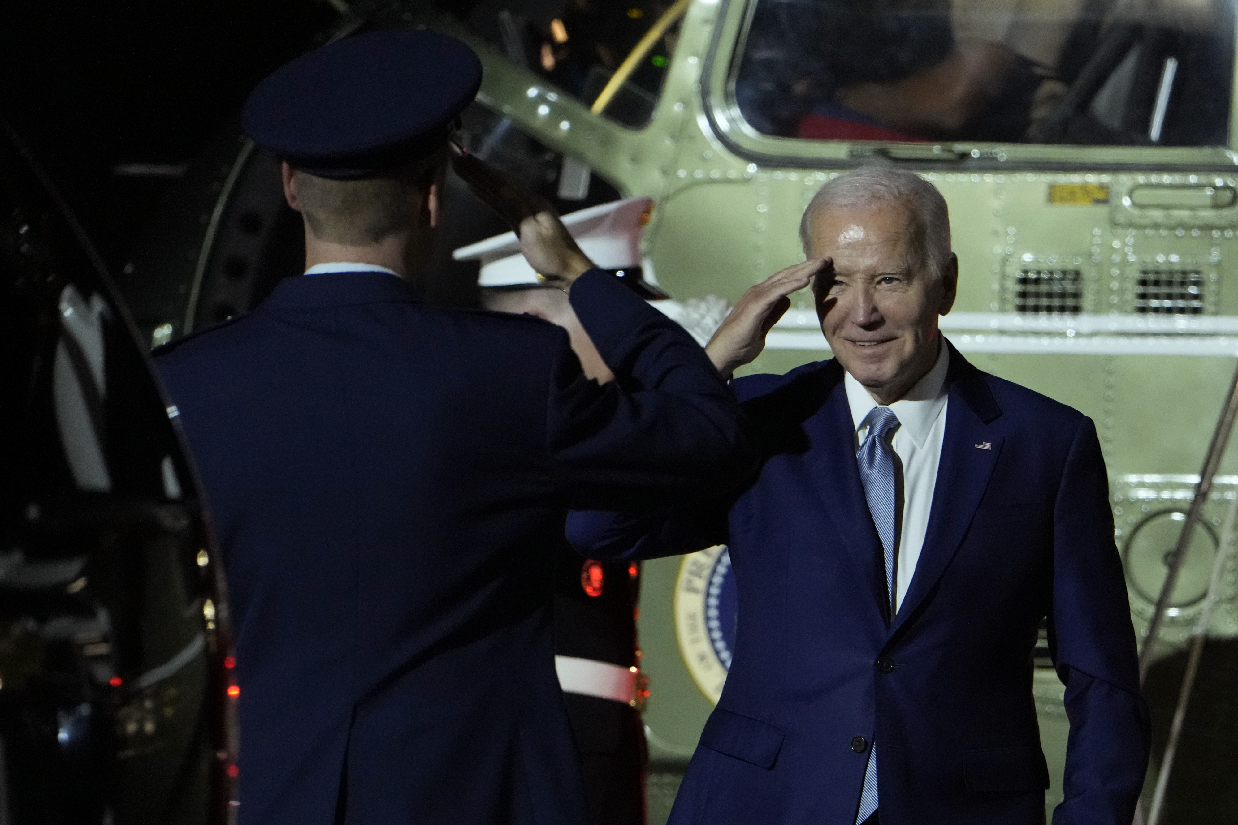 바이든 대통령이 지난 27일(현지시간) 워싱턴 델라웨어 공군 기지에 착륙한 마린원 헬기에서 내리며 경례를 받고 있다.  AP=연합뉴스