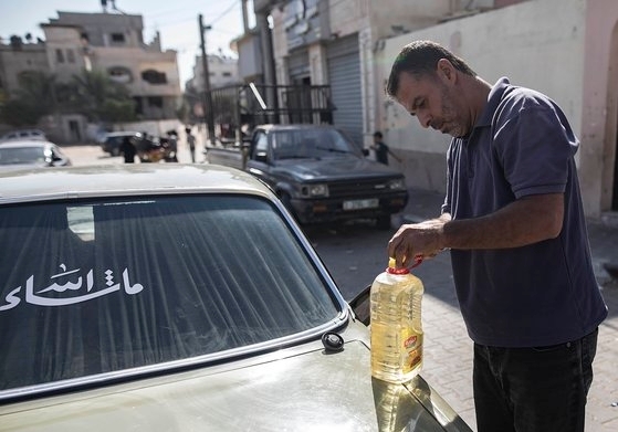 30일(현지시간) 가자지구 남부 칸 유니스의 주유소에 연료가 떨어져 한 팔레스타인인 운전자가 식용유를 대신 사용하고 있다. EPA=연합뉴스