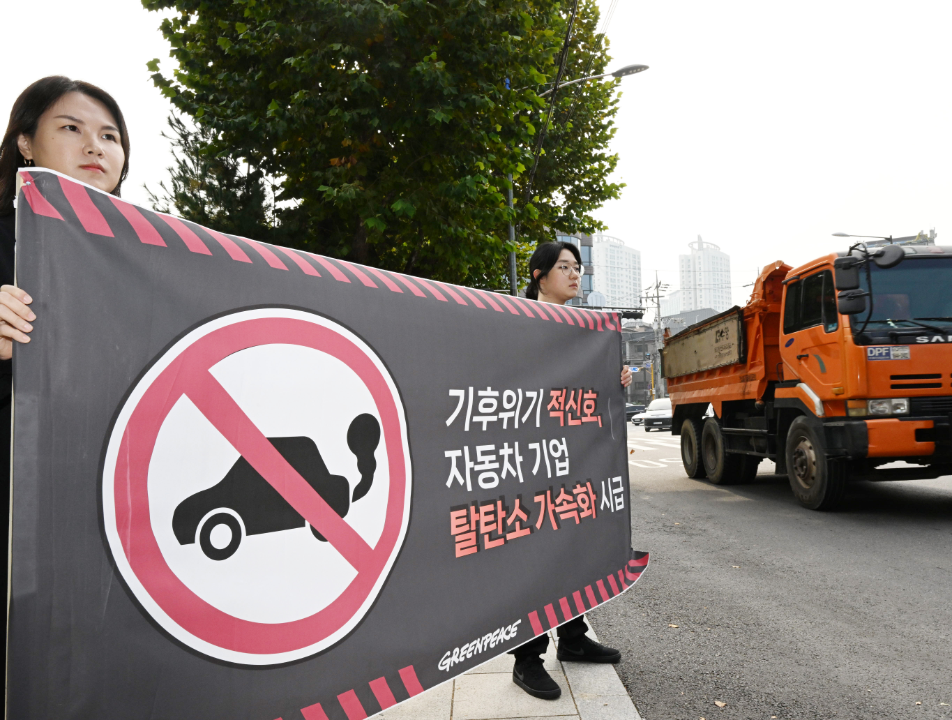 국제환경단체 그린피스 서울사무소에서 전기차 전환 캠페이너로 활동하는 홍혜란(왼쪽), 최은서씨가 31일 서울 양재동의 한 도로에서 내연기관차 판매 중단을 촉구하는 캠페인을 벌이고 있다. 도준석 기자