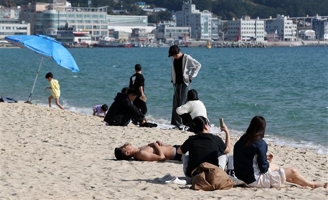 11월 늦더위가 기승을 부린 3일 오후 부산 해운대해수욕장에서 상의를 탈의한 외국인이 해변에 누워 휴식하고 있다. 2023.11.3. 뉴스1