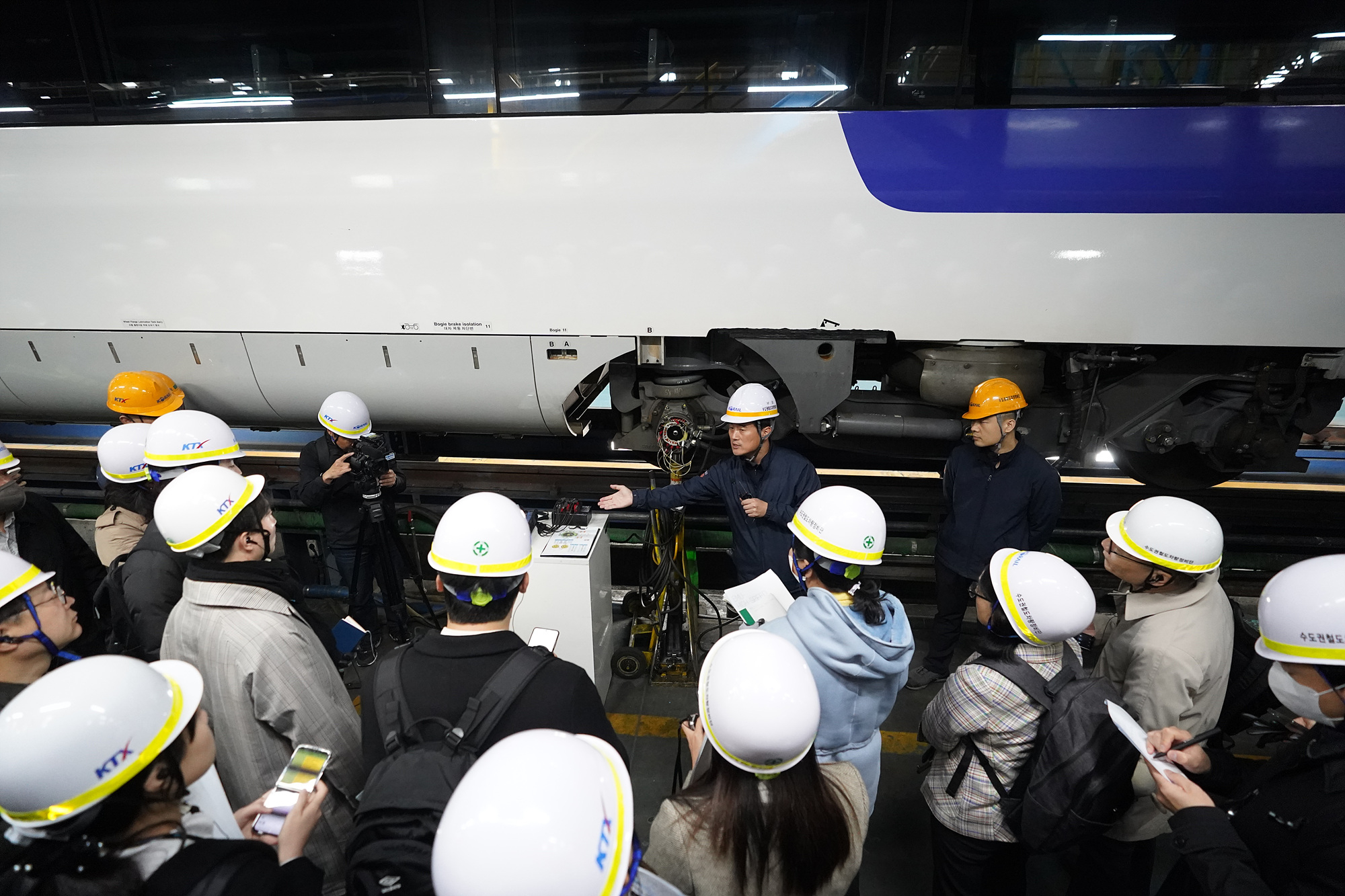 수도권철도차량정비단 경정비동에서 점검이 이뤄지는 모습을 코레일 직원이 설명하고 있다. (사진=코레일 제공)