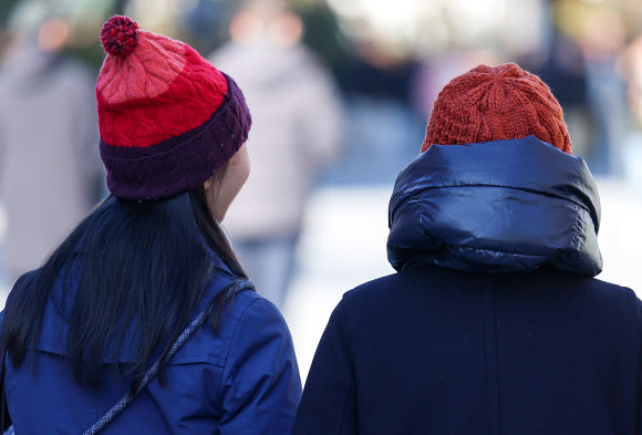 비가 그치며 서울 최저기온이 1도까지 떨어진 10일 서울 종로구 광화문광장에서 시민들이 방한모자를 쓰고 있다. 2023.11.10 연합뉴스