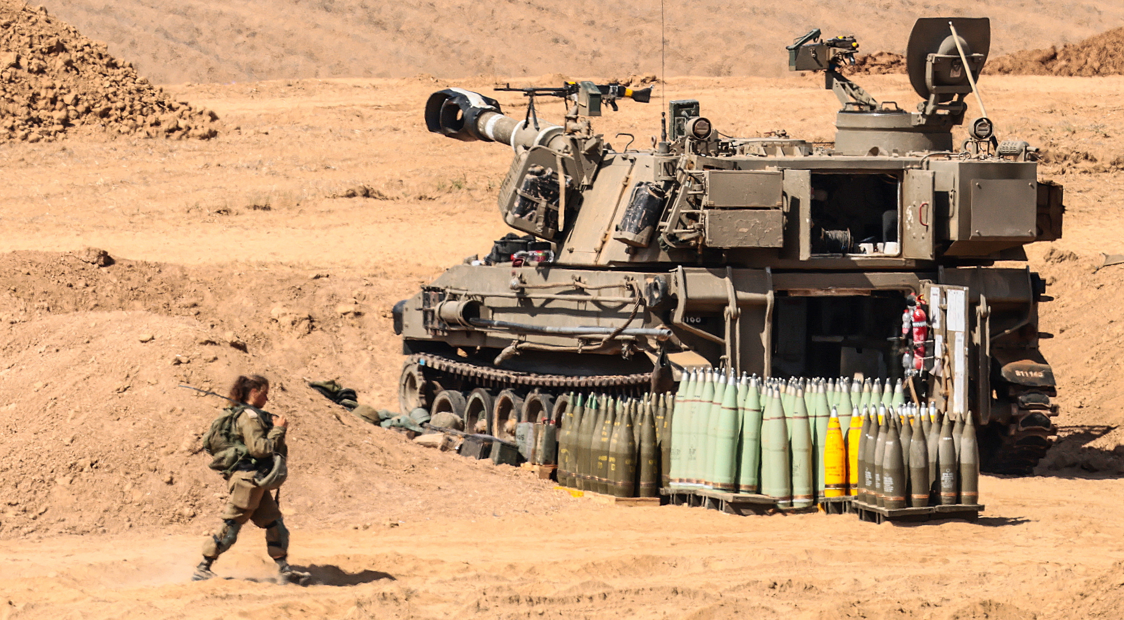 25일(현지시간) 이스라엘 군인이 가자지구 국경 근처에 배치된 M109 자주포 앞을 지나고 있다. 2023.10.25. EPA 연합뉴스