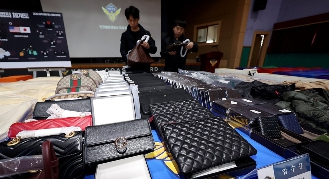 해경 수사관들이 압수한 가짜 명품들을 살펴보고 있다. 연합뉴스