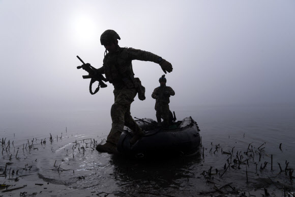 우크라이나군 병사들이 지난 15일(현지시간) 헤르손주 드니프로강 둑에 닿은 보트에서 뛰어내리고 있다. AP 자료사진 연합뉴스