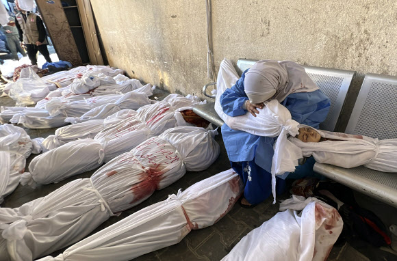 팔레스타인 여성이 18일(현지시간) 가자지구 북부 인도네시안 병원에서 자발리아 난민촌을 겨냥한 이스라엘 공습에 희생된 아이의 시신을 끌어안고 오열하고 있다. 자발리아 AP 연합뉴스