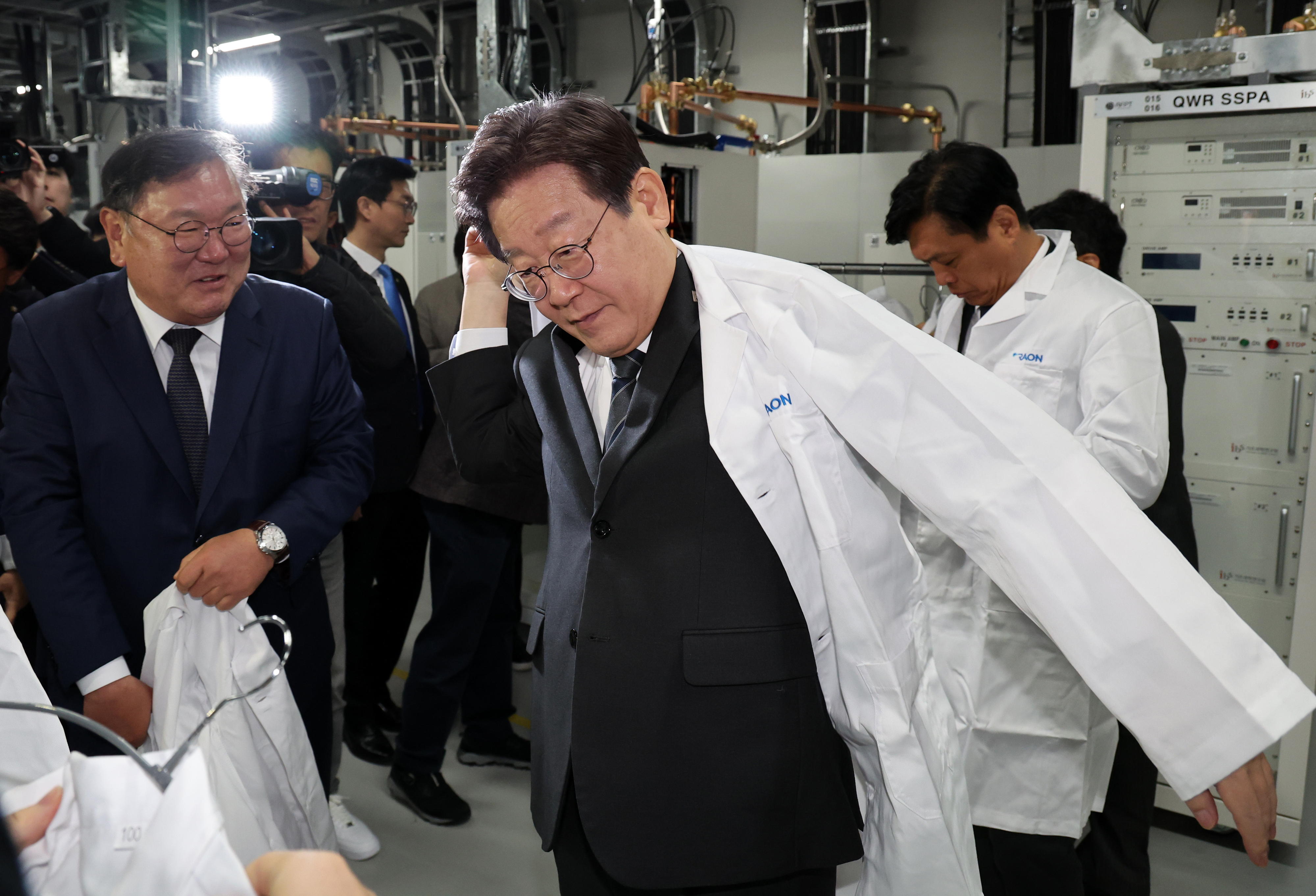 이재명 대표, 중이온가속기 현장 시찰  이재명 더불어민주당 대표가 15일 오후 대전 유성구 기초과학연구원(IBS)을 찾아 중이온가속기 등 시설을 살펴보기에 앞서 가운을 입고 있다. 2023.11.15/뉴스1