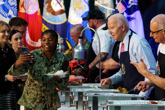 조 바이든 미국 대통령이 19일(현지시간) 버지니아주 노퍽 해군기지를 방문해 군 장병과 가족들에게 배식해주며 셀피 촬영에 응하고 있다. 노퍽 기지 EPA 연합뉴스
