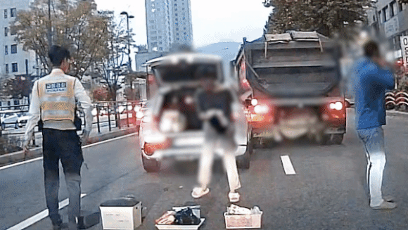 서울 서초구의 한 도로에서 접촉사고를 낸 뒤 트렁크 속 물건을 도로 위에 늘어놓는 등 이상행동을 하는 운전자. 이 운전자는 마약 간이시약 검사 결과 양성으로 나타났다. 
서울경찰청 제공