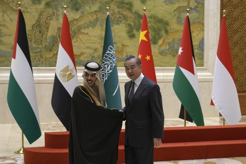 왕이(오른쪽) 중국 외교부장이 20일 파이살 빈 파르한 사우디아라비아 외교장관과 악수하고 있다. 베이징 AP 연합뉴스