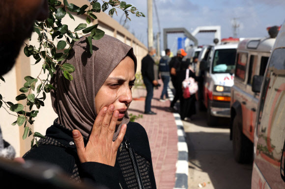 팔레스타인 가자지구 최대 의료시설인 알시파 병원 산부인과에서 치료를 받던 조산아의 어머니 루브나 엘세이크가 20일(현지시간) 이집트로 빠져나가는 라파 국경검문소를 통과하기 위한 앰뷸런스 행렬 옆에서 초조한 기색을 감추지 못하고 있다. 라파 AFP 연합뉴스
