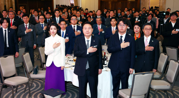 영국을 국빈 방문한 윤석열 대통령과 부인 김건희 여사가 20일(현지시간) 런던의 한 호텔에서 열린 동포 만찬 간담회에서 국기에 경례하고 있다. 2023.11.21  연합뉴스