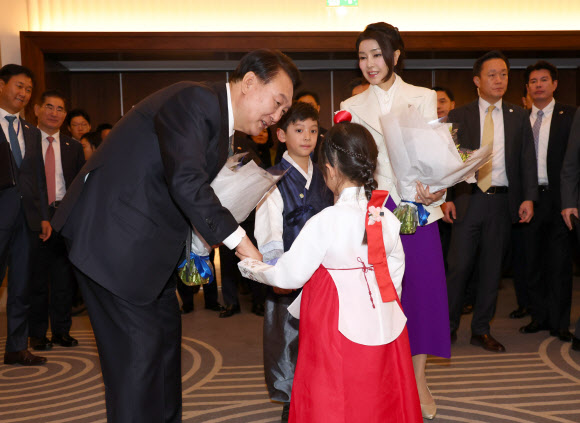 영국을 국빈 방문한 윤석열 대통령과 부인 김건희 여사가 20일(현지시간) 런던의 한 호텔에서 열린 동포 만찬 간담회에서 화동으로부터 꽃다발을 받고 있다. 2023.11.21  연합뉴스