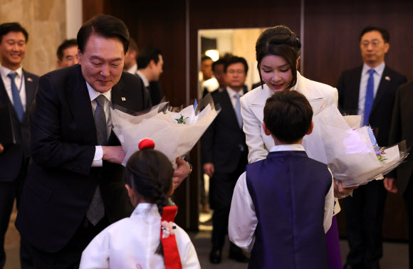 영국을 국빈 방문한 윤석열 대통령과 부인 김건희 여사가 20일(현지시간) 런던의 한 호텔에서 열린 동포 만찬 간담회에서 화동으로부터 꽃다발을 받고 있다. 2023.11.21  공동취재