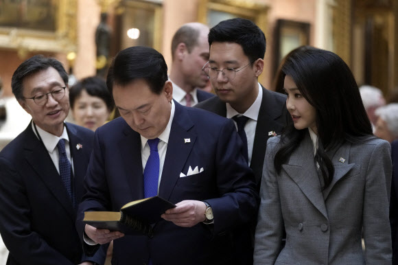 The President of Korea Yoon Suk Yeol, centre, and First Lady, Kim Keon Hee look at a display of Korean items from the Royal Collection, inside Buckingham Palace in London, Tuesday, Nov. 21, 2023. The President of Korea Yoon Suk Yeol is on a four-day State visit to Britain. AP 연합뉴스