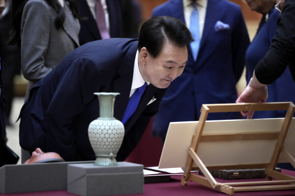 The President of Korea Yoon Suk Yeol takes a closer look at a display of Korean items from the Royal Collection, during a visit with Britain‘s King Charles inside Buckingham Palace in London, Tuesday, Nov. 21, 2023. The President of Korea Yoon Suk Yeol is on a four-day State visit to Britain. AP