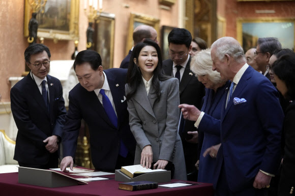 Britain‘s King Charles, right, with Queen Camilla, shows The President of Korea Yoon Suk Yeol, left and First Lady, Kim Keon Hee, second left, a display of Korean items from the Royal Collection, inside Buckingham Palace in London, Tuesday, Nov. 21, 2023. The President of Korea Yoon Suk Yeol is on a four-day State visit to Britain. AP 뉴시스
