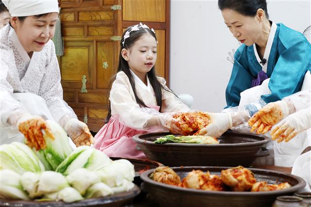 22일 서울 강남구 aT센터에서 열린 ‘제4회 김치의 날’ 행사에서 한 어린이가 김장담그기 시연을 돕고 있다. 2023.11.22. 뉴스1