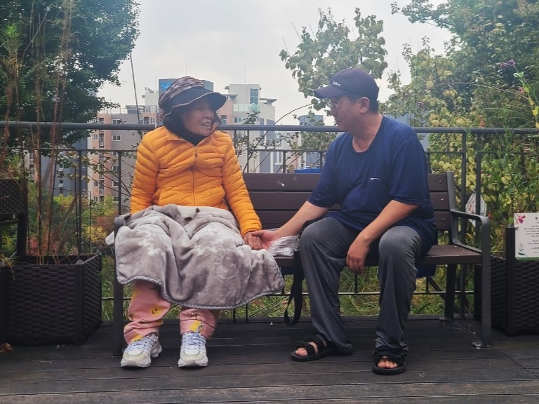 중구 ‘우리 동네 숨은 파수꾼’ 선용규(오른쪽)씨가 노모와 함께 공원에서 대화하고 있다.   중구 제공