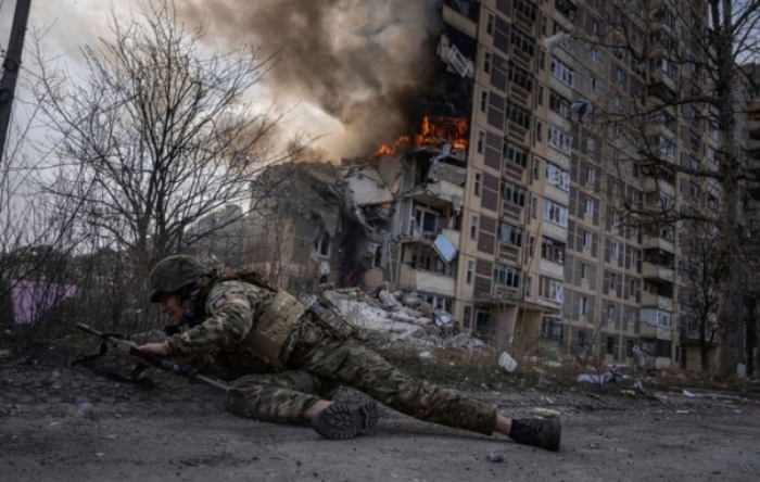 우크라이나 아우디이우카에서 한 경찰관이 러시아군의 공습으로 불타는 건물 주변으로부터 몸을 피하고 있다. AP 뉴시스