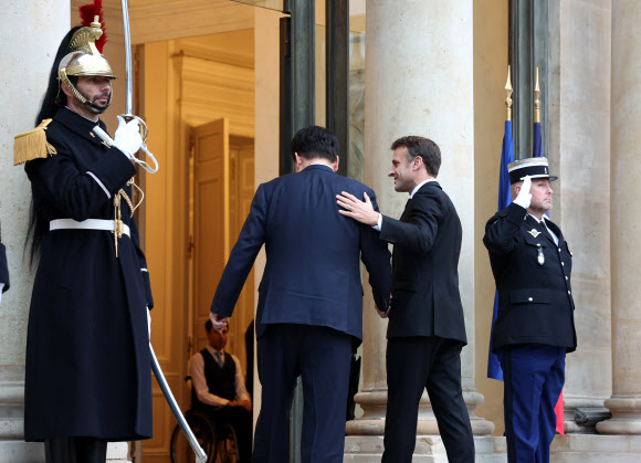 부산엑스포 유치활동을 위해 프랑스를 방문한 윤석열 대통령이 24일(현지시간) 파리 엘리제궁에서 열린 한·프랑스 조찬 겸 정상회담에서 에마뉘엘 마크롱 대통령과 기념 촬영한 뒤 입장하고 있다. 2023.11.24 연합뉴스