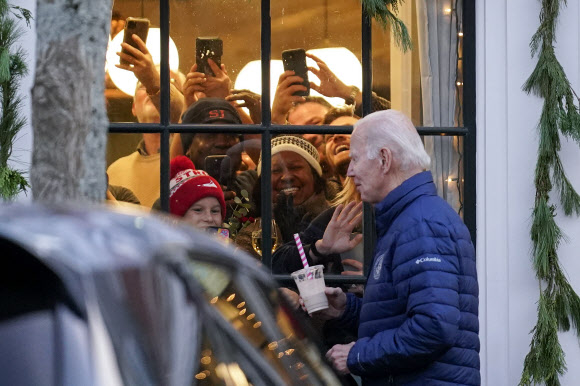 조 바이든 미국 대통령이 추수감사절 연휴를 지내는 매사추세츠주 낸터킷에서 친척들과 쇼핑을 즐기던 중 음료수 통을 든 채 가게 앞을 지나치자 창문 안 사람들이 신기한 듯 카메라에 담고 있다. 낸터킷 AP 연합뉴스