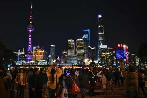 중국인들이 25일 상하이 푸동거리에서 화려한 마천루의 조명을 즐기고 있다. 상하이 AP 연합뉴스