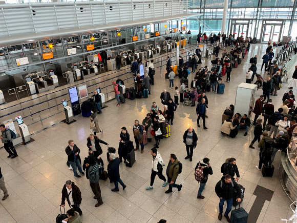 승객들이 2일(현지시간) 폭설로 오도가도 못한 신세가 된 독일 뮌헨공항에서 혹시나 싶어 긴 줄을 서 있다. 뮌헨 로이터 연합뉴스