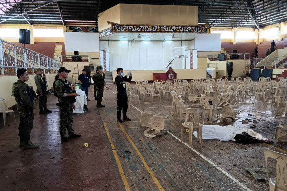필리핀 사법당국 관계자들이 3일 남부 민다나오섬 마라위 시에 있는 민다나오주립대 체육관에서 일요 미사 중 터진 폭탄 테러 여파로 적어도 4명이 숨진 현장을 보존하며 증거를 찾고 있다. 라나오 델 수르 지역정부 공보실 제공 AP 연합뉴스