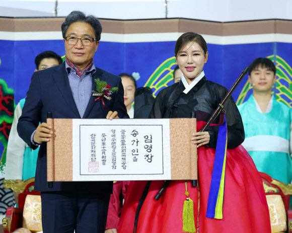 이학재 인천국제공항공사 사장이 4일 인천공항 제1여객터미널에서 열린 명예 수문장 임명식에서 가수 송가인에게 임명장을 수여한 뒤 기념 촬영을 하고 있다. 2023.12.4 연합뉴스