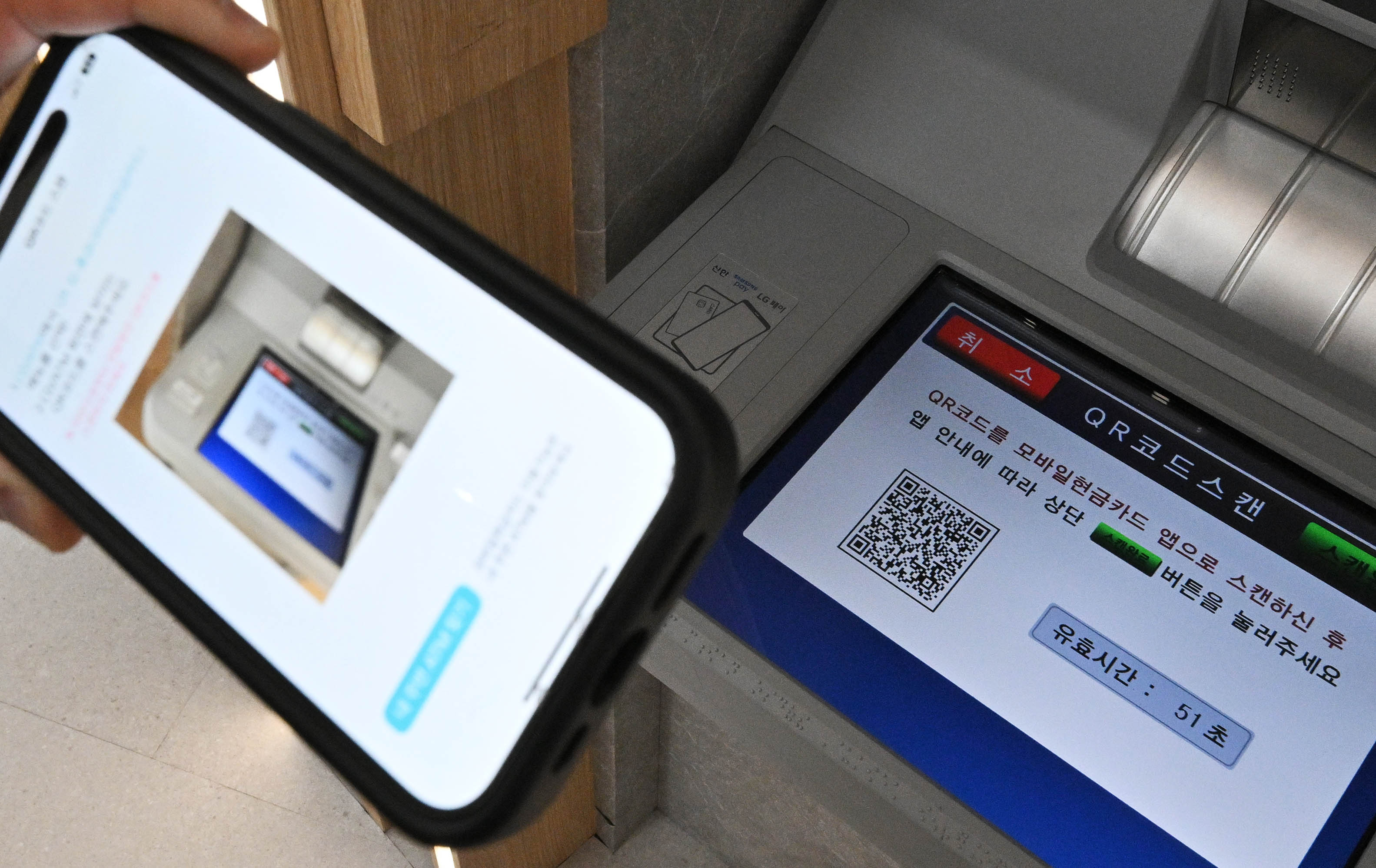 6일 서울 중구 신한은행 본점 현금자동입출금기(ATM)에서 고객이 모바일 뱅킹 앱의 QR코드를 활용해 출금을 하고 있다. 2023.12.6 홍윤기 기자