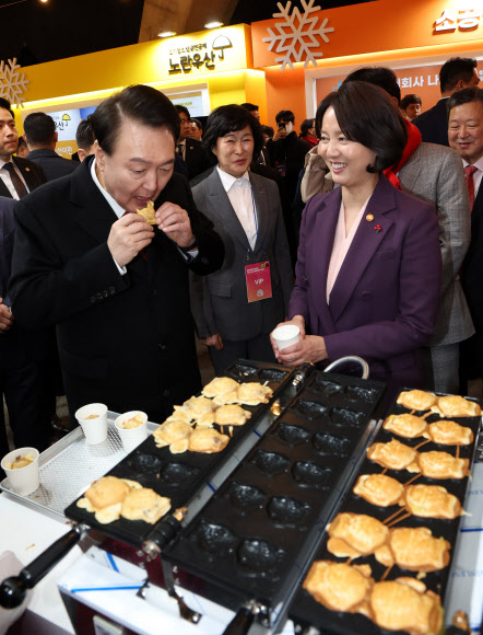 윤석열 대통령이 7일 오후 서울 중구 동대문디자인플라자(DDP)에서 열린 2023년 눈꽃 동행축제 현장을 찾아 전국카페사장협동조합에서 무료로 나눠주는 붕어빵을 시식하고 있다. 2023.12.7  연합뉴스