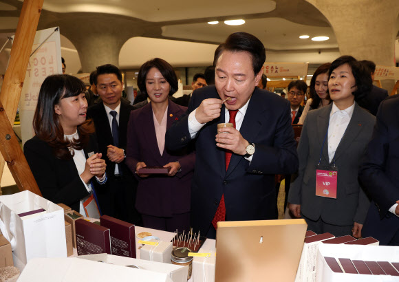 윤석열 대통령이 7일 오후 서울 중구 동대문디자인플라자(DDP)에서 열린 2023년 눈꽃 동행축제 현장을 찾아 카카오패밀리 부스에서 아몬드넛버터를 맛보고 있다. 2023.12.7  연합뉴스
