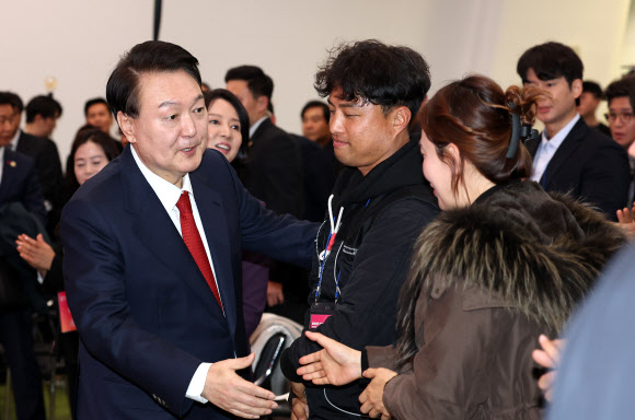 윤석열 대통령이 7일 오후 서울 중구 동대문디자인플라자(DDP)에서 열린 2023년 눈꽃 동행축제 개막행사에 입장하며 참석자들과 인사하고 있다. 2023.12.7  연합뉴스